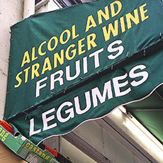 Une faute de traduction sur l’auvent d’une épicerie sur le boulevard de Clichy: Stranger Wine pour Vin étranger.