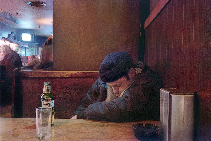 A man sleeping in the Blue Sands bar in Boston.