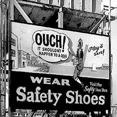Un panneau sur la qui veut convaincre des ouvriers de porter des chaussures de sécurité.