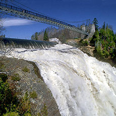 A footbridge traverses the falls at Parc de la Chute Montmorency