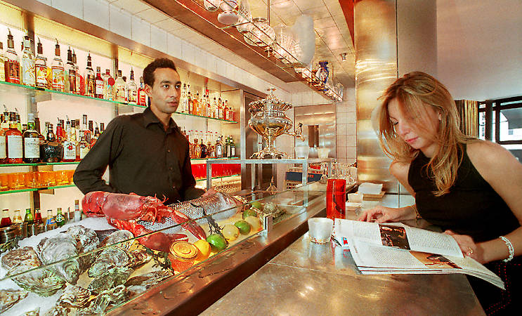 A barman and a waitress at the counter inside the Lô Sushi and Bon restaurant.